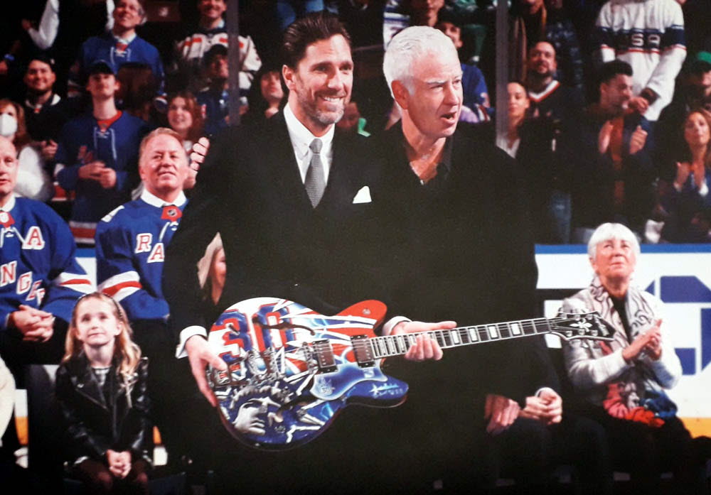 Henrik Lundkvist med den gitarr som David målat. Och John MacEnroe