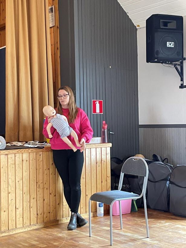 Emma demonstrerar på en docka.